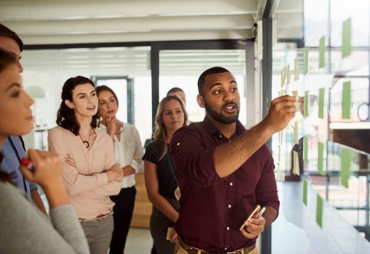 Group work at the office. A man presenting his ideas in front of a group of people at work.