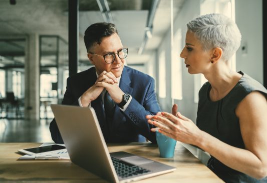 A man and a woman talking business at work