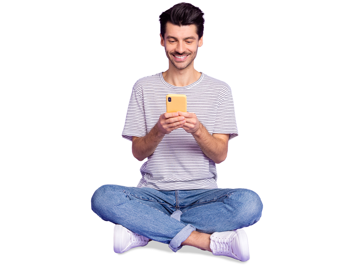 Smiling man using phone and sitting