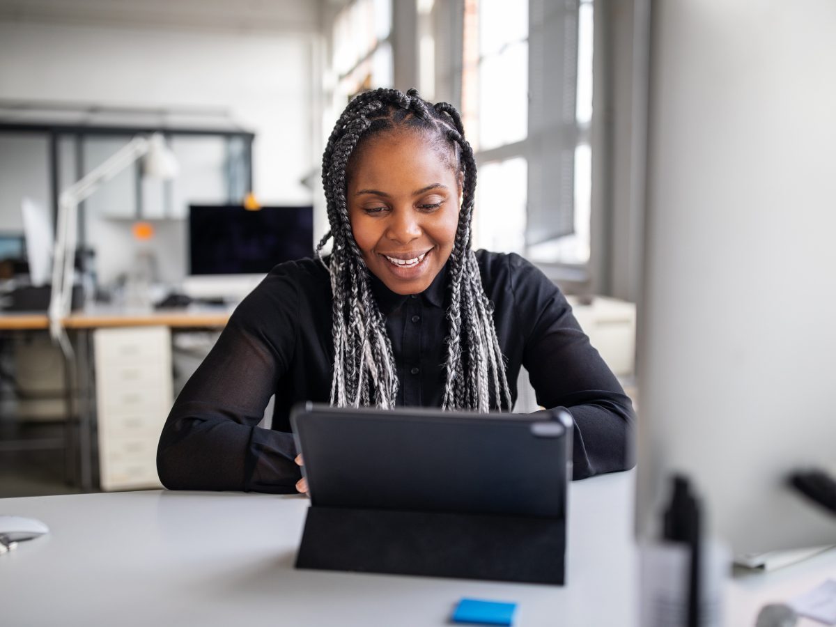 Woman on computer smiling at work