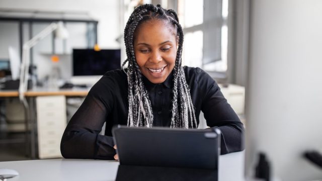Woman on computer smiling at work