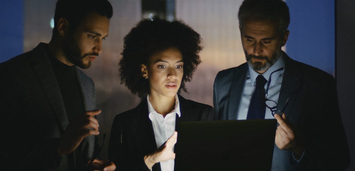 CrossKnowledge Video, 3 people in the dark looking at a computer.