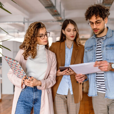 Learning and Development team gathered in a meeting room, looking at performance reports on a laptop, questioning why upskilling efforts have not led to better employee performance.