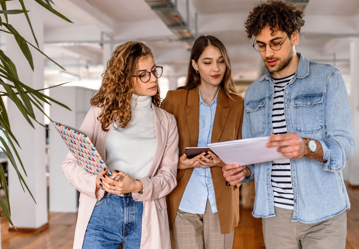 Learning and Development team gathered in a meeting room, looking at performance reports on a laptop, questioning why upskilling efforts have not led to better employee performance.
