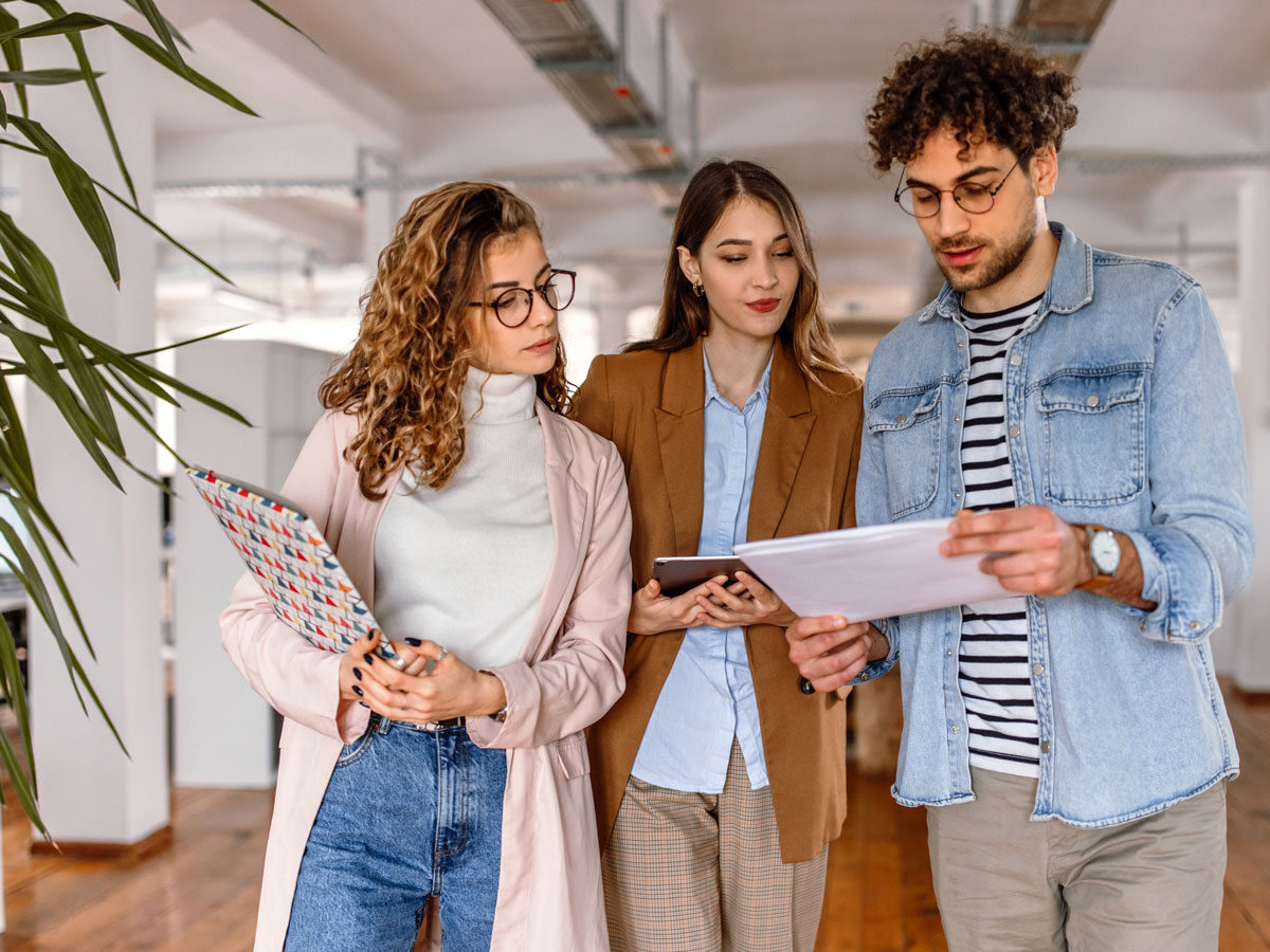 Learning and Development team gathered in a meeting room, looking at performance reports on a laptop, questioning why upskilling efforts have not led to better employee performance.